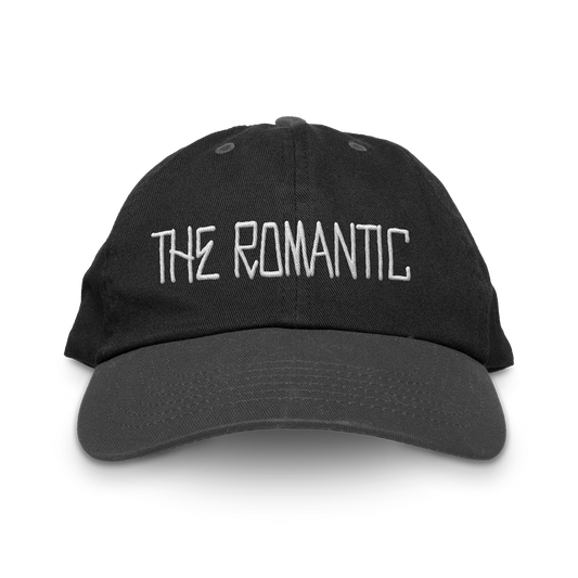 Front of a Unisex black baseball cap with "The Romantic" embroidered on the front in white.